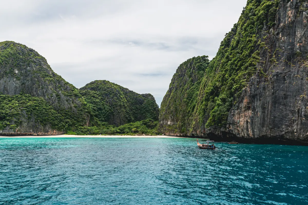 Maya Bay on Phi Phi Leh, one of the must-see attractions in Southern Thailand, with limestone cliffs and turquoise water.