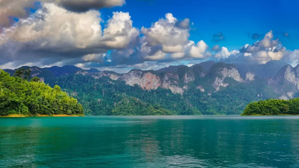 Must see attractions Thailand featuring the limestone cliffs and emerald waters of Khao Sok National Park and Cheow Lan Lake.