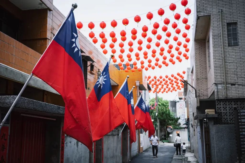 Malaysian flags and traditional lanterns in a cultural street setting, representing Malaysia's multicultural identity, heritage and travel experiences.