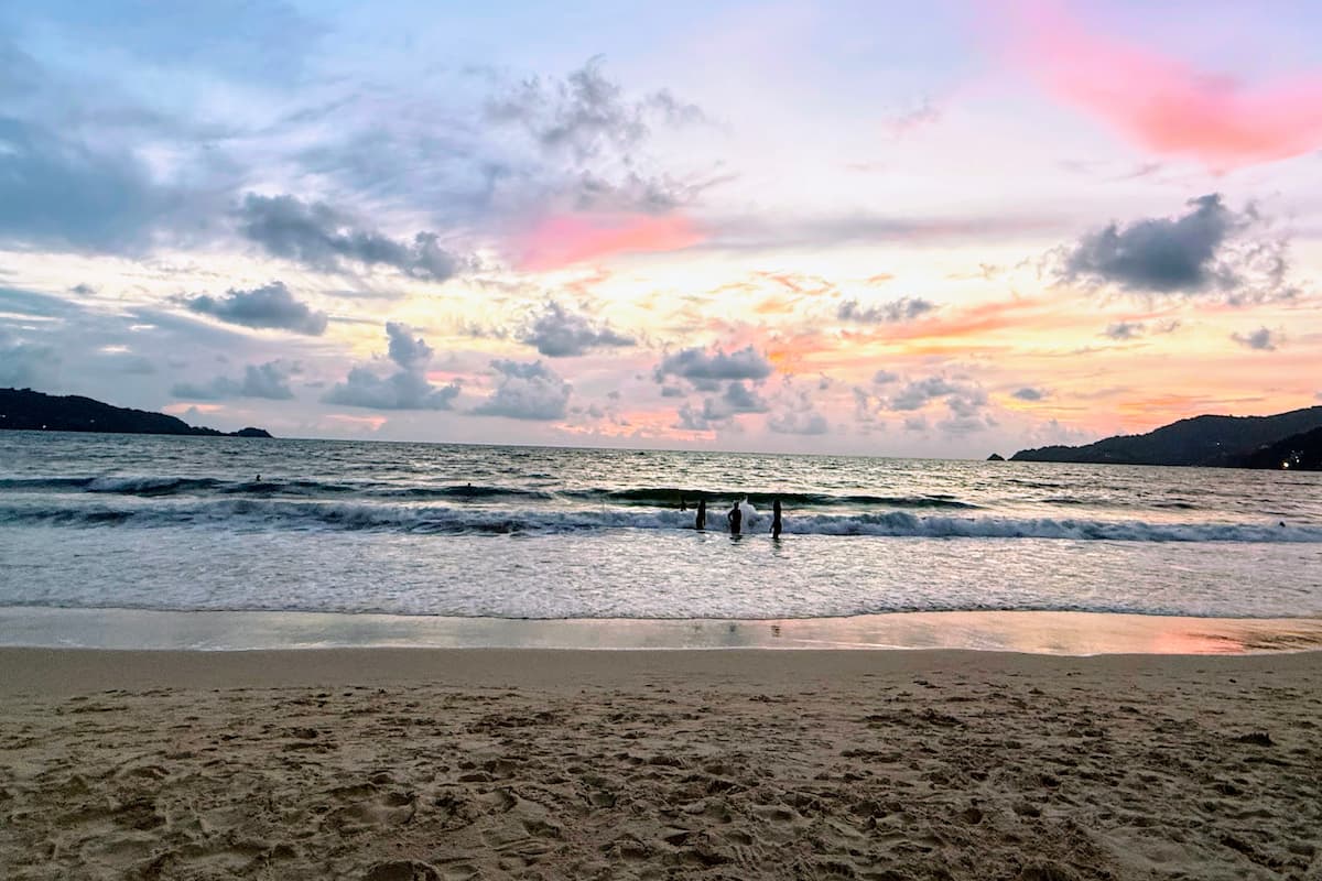 Visitors enjoying sunset at Patong Beach, one of the best free things to do in Patong.