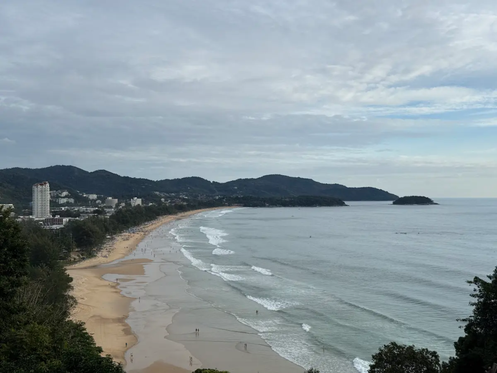 Travel With Insight view overlooking Karon Beach in Phuket, showing the sweeping coastline, golden sand and surrounding headlands
