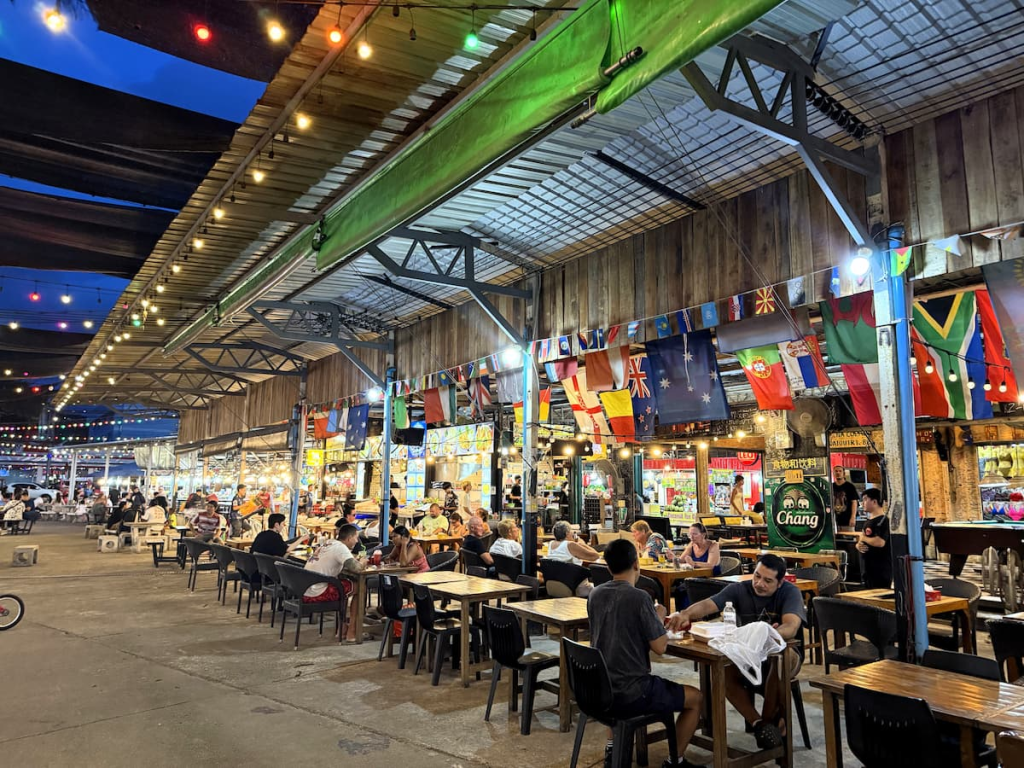 Evening view through Malin Plaza Patong with illuminated food stalls and string lights.