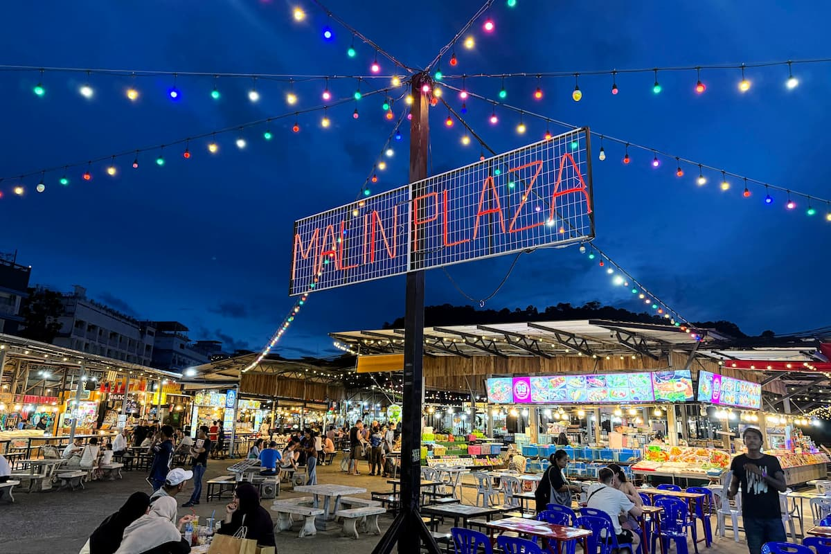 Malin Plaza Patong sign illuminated at blue hour above the night market.