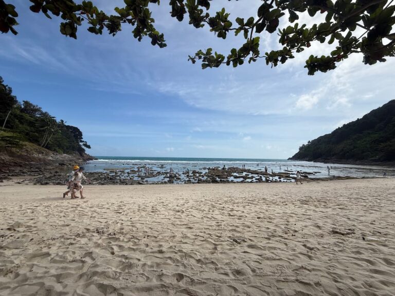 Merlin Beach in Phuket, showing the sandy bay, rocky reef and forested headlands