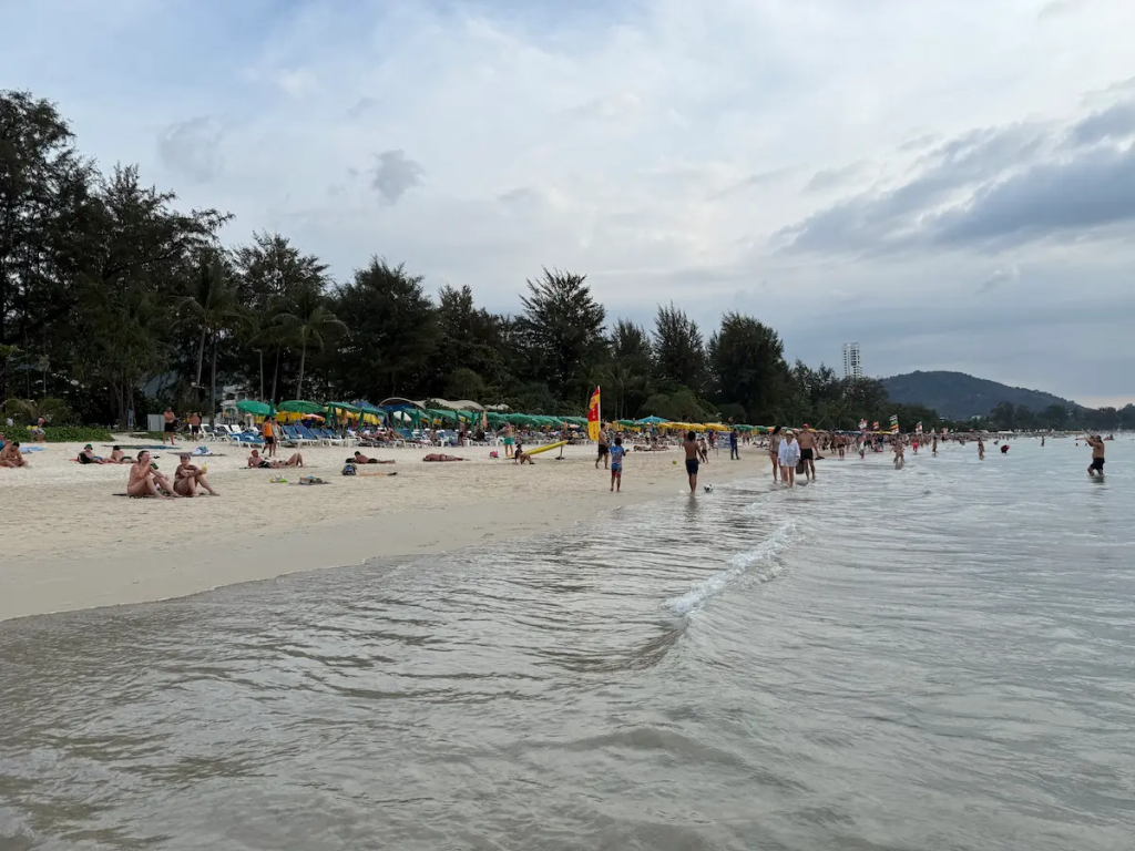 Visitors relaxing on the wider northern section of Patong Beach near Loma Park, a quieter area to consider when planning your first visit to Patong.