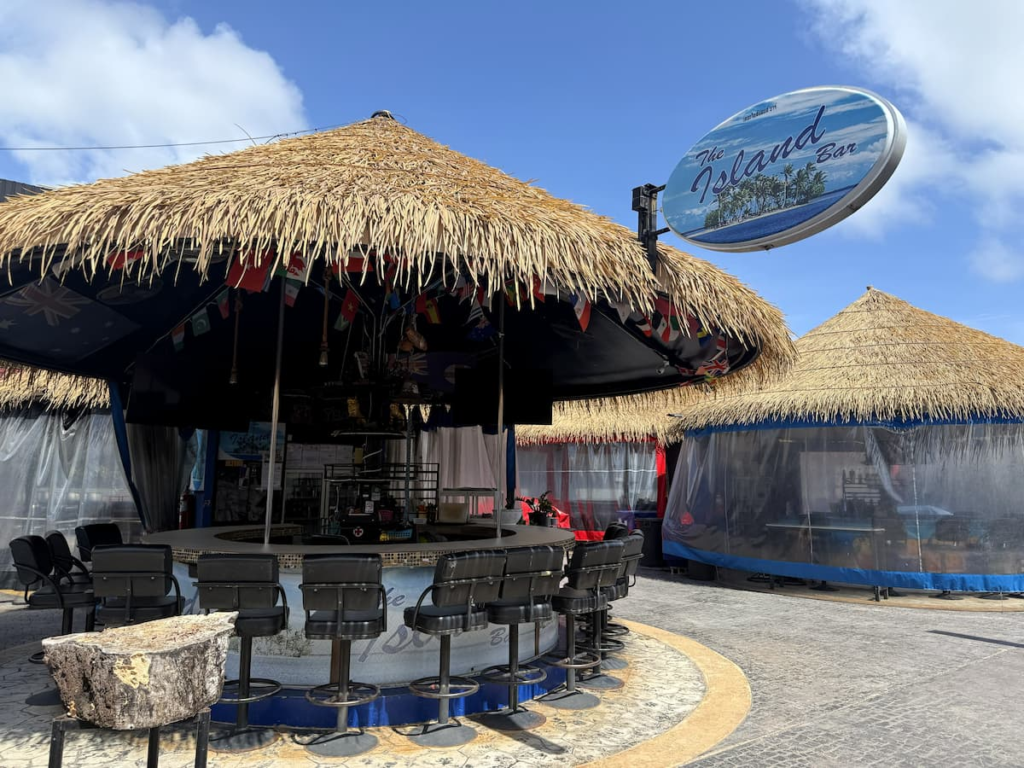 Open-air bar with stools and thatched roof at OTOP Patong.