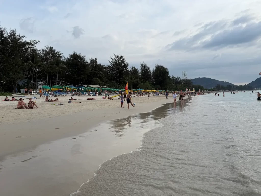 Patong travel guide showing visitors enjoying the central shoreline of Patong Beach in Phuket.