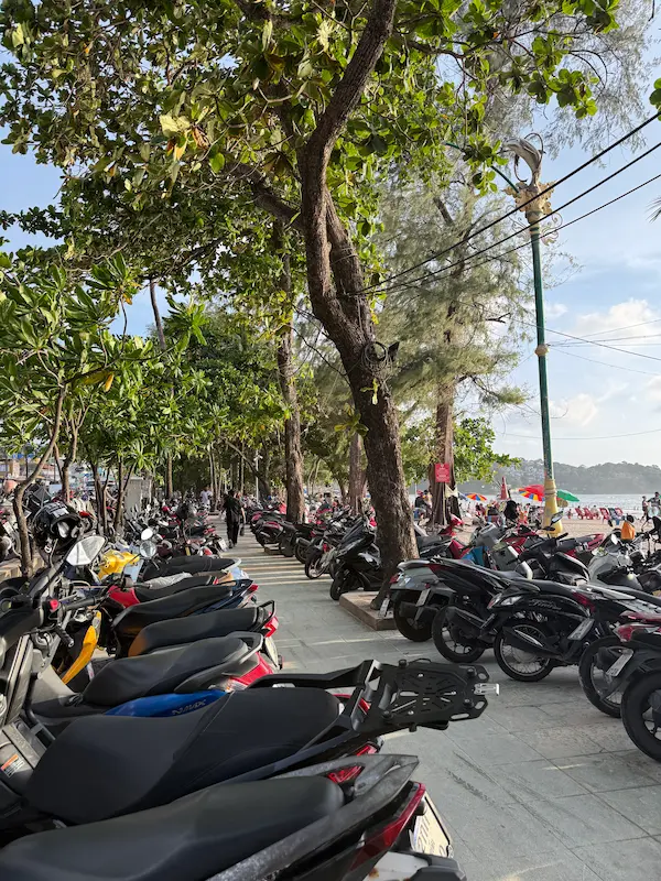 Scooter parking along the beachfront promenade at Patong Beach featured in our Patong Travel Guide.