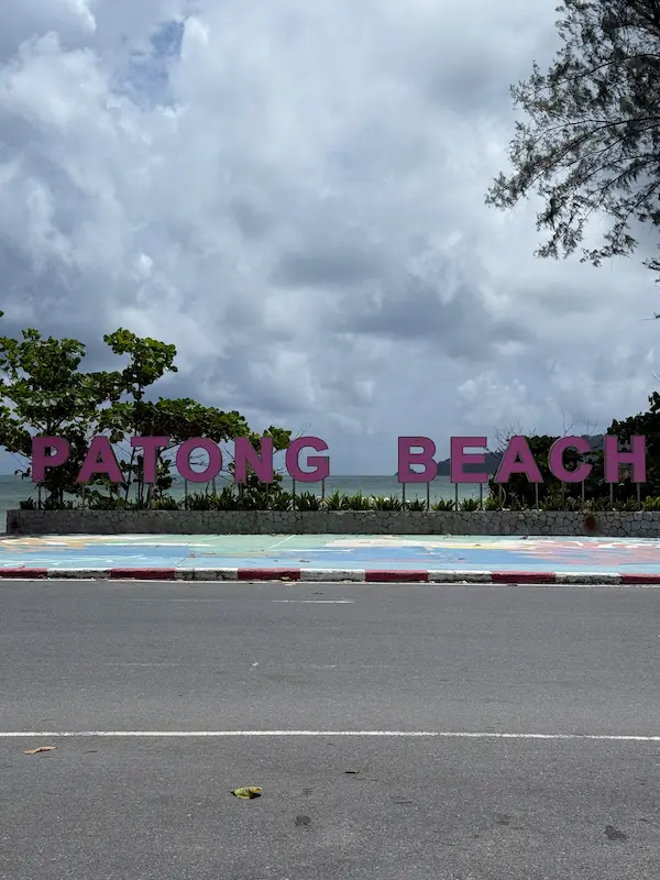 The Patong Beach sign on Phuket's beachfront, located across the road from the Patong Phra Phrom Shrine.