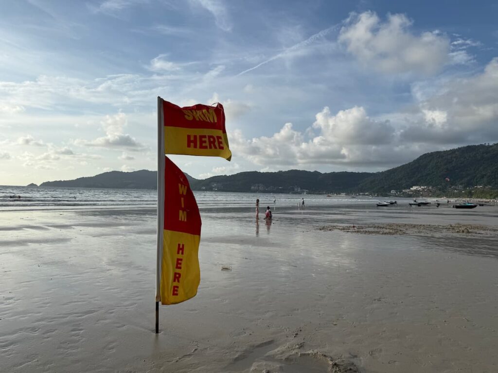 Swimming flags marking the safe swimming area during water sports in Patong at Patong Beach, Phuket.