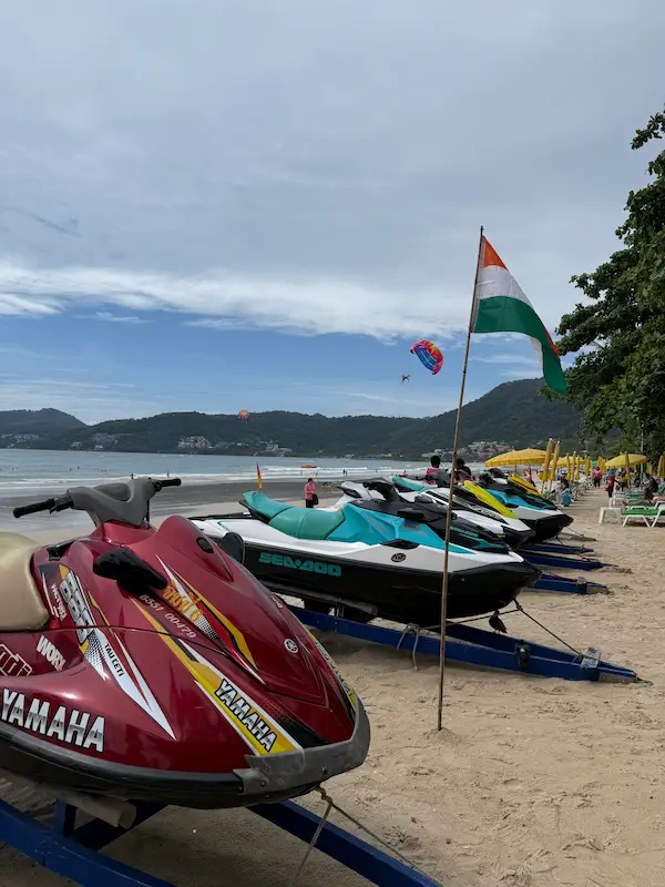 Jet skis and parasailing on Patong Beach, showing some of the popular water sports available along Phuket's busiest public beach.