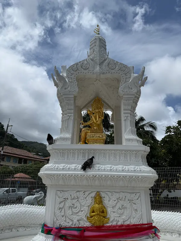 The four-faced Phra Phrom (Brahma) statue inside the Patong Phra Phrom Shrine in Phuket, surrounded by traditional Thai shrine architecture.