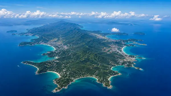 Aerial view of Phuket Island showing its tropical coastline, forested hills and surrounding Andaman Sea, featured in our Phuket travel guide.