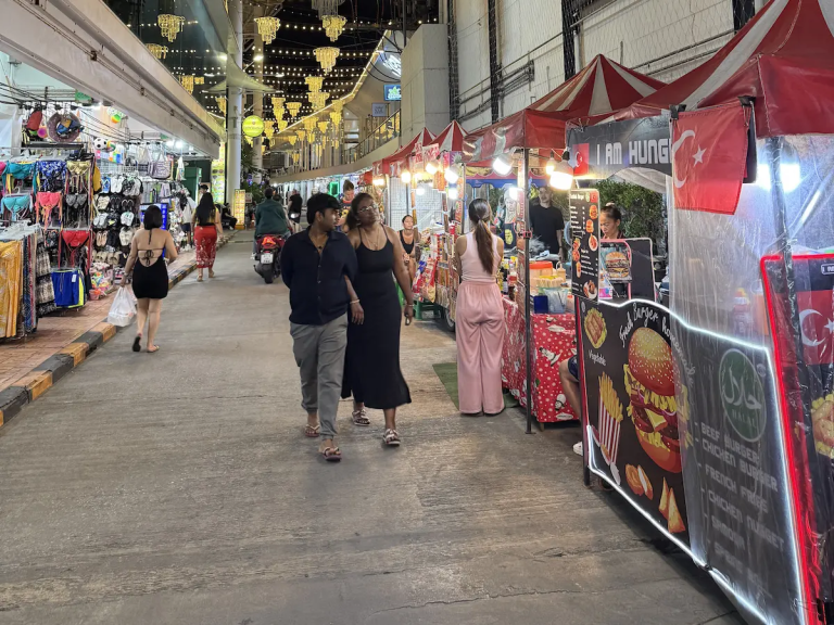 Shopping in Patong with visitors browsing clothing, souvenir and street food stalls during the evening.