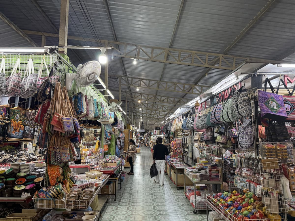 Market aisle lined with bags, souvenirs, clothing and accessories at Malin Plaza Patong.