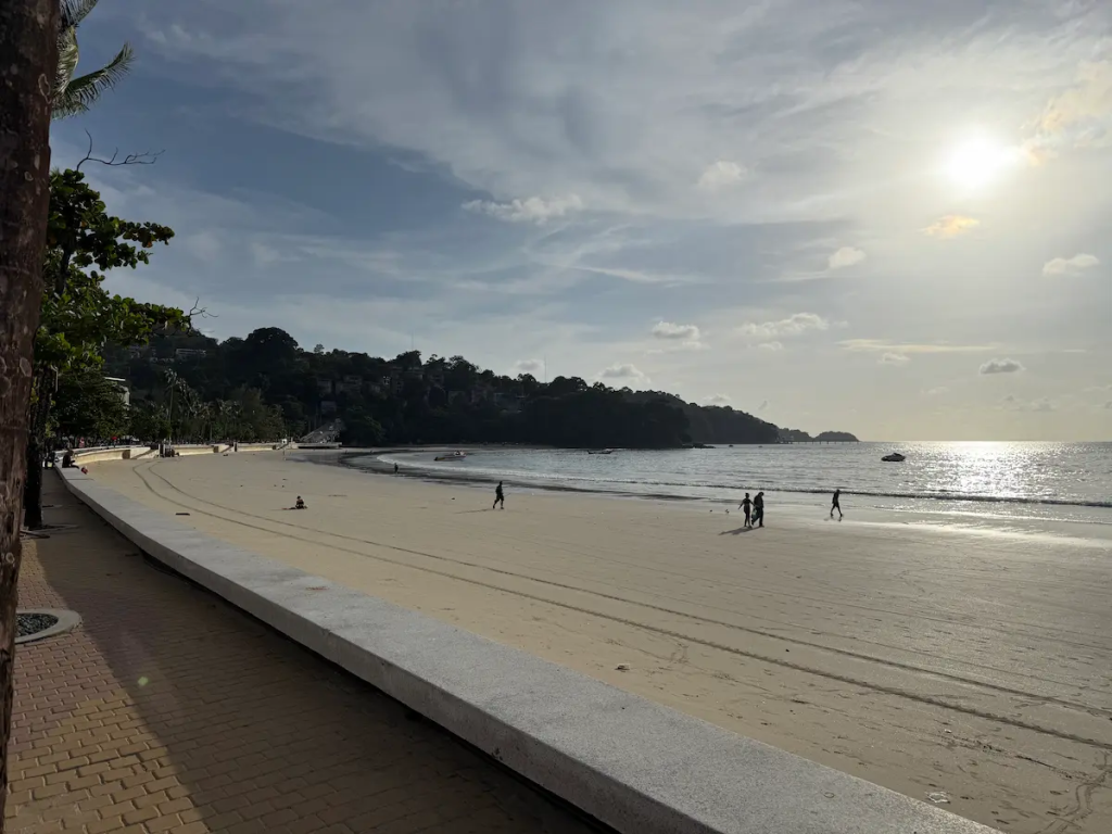 The quieter southern section of Patong Beach with the beachfront promenade and headland featured in our Patong Travel Guide.