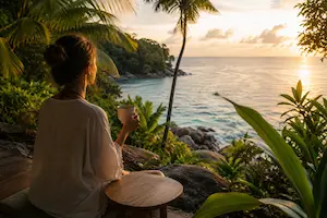 Traveller enjoying a peaceful sunrise overlooking the ocean in Southeast Asia, representing wellness travel, relaxation and mindful experiences.