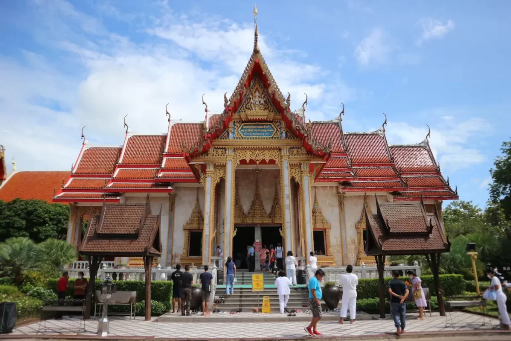 Wat Chalong, Phuket's largest and most important Buddhist temple, featuring its ornate Thai architecture and welcoming visitors.