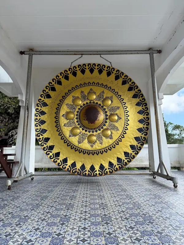 Large ceremonial Buddhist gong inside the Bell Pavilion at Wat Doi Thep Nimit in Phuket.