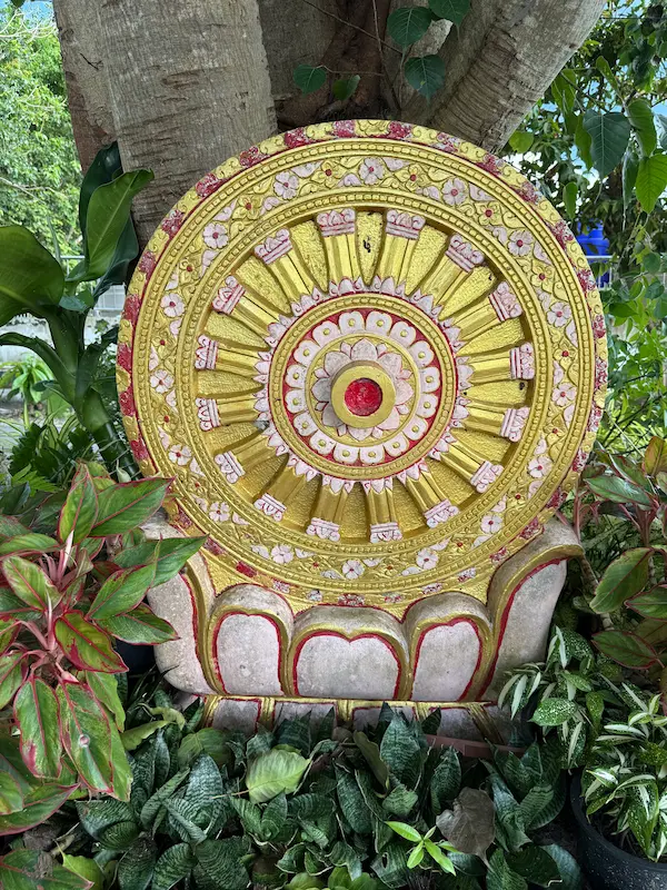 Decorative Dhammachakra, or Wheel of Dhamma, displayed in the gardens at Wat Doi Thep Nimit in Phuket.