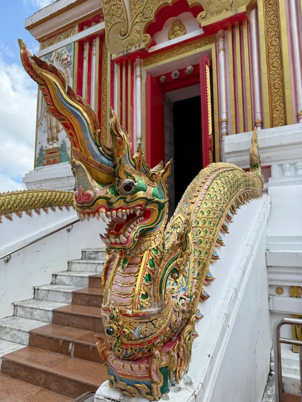 Decorative naga beside the short entrance staircase to the Phra Maha Chedi at Wat Doi Thep Nimit in Phuket.