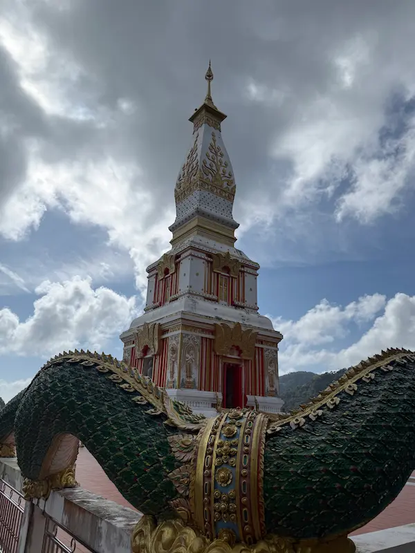 The continuous naga guardians surrounding the Phra Maha Chedi terrace at Wat Doi Thep Nimit in Phuket.