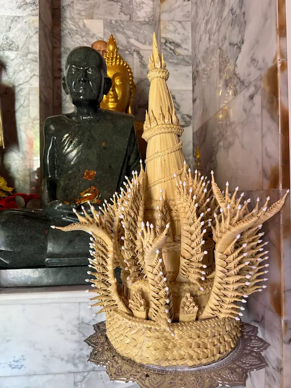 Traditional palm leaf chedi offering displayed inside the sacred chedi at Wat Doi Thep Nimit in Phuket.