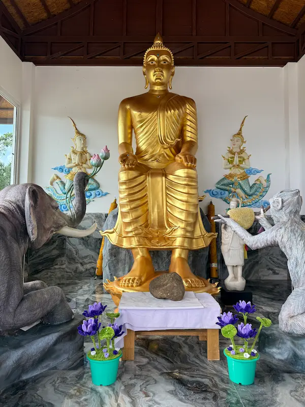 Phra Phuttha Palilai Buddha statue with the elephant Parileyyaka and monkey offering honey at Wat Doi Thep Nimit in Phuket.