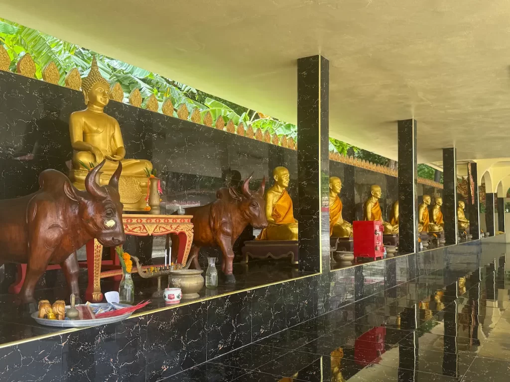 Buddha image and memorials to revered monks inside the open sala at Wat Suwan Khiri Wong Patong