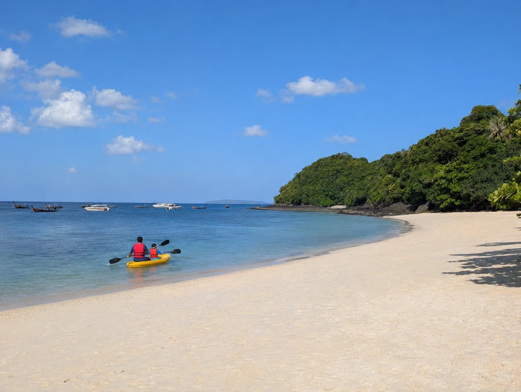 An adult and child wearing life jackets while kayaking at Banana Beach during a Southern Thailand family holiday.