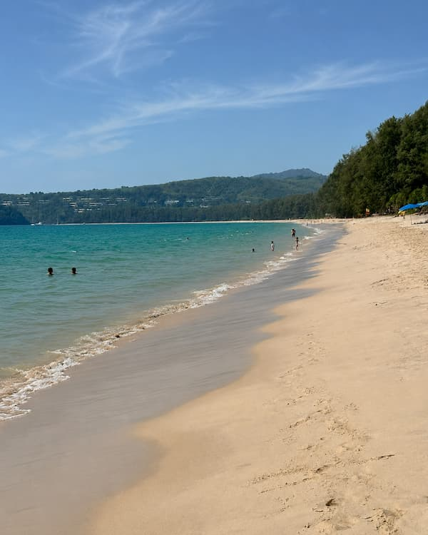 Spacious shoreline and calm coastal water at Bang Tao Beach, featured in a Phuket travel guide