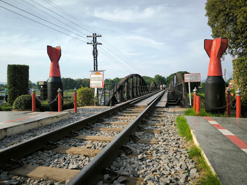 Thailand travel guide view along the railway tracks crossing the Bridge over the River Kwai in Kanchanaburi.