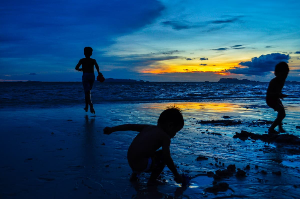 Children playing on a Koh Samui beach at sunset in a guide to Southern Thailand with children.