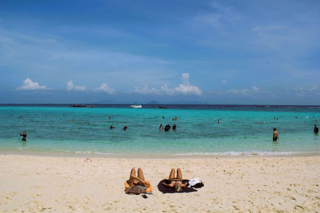 Travellers relaxing on a Thai beach during a slow-paced Thailand holiday.