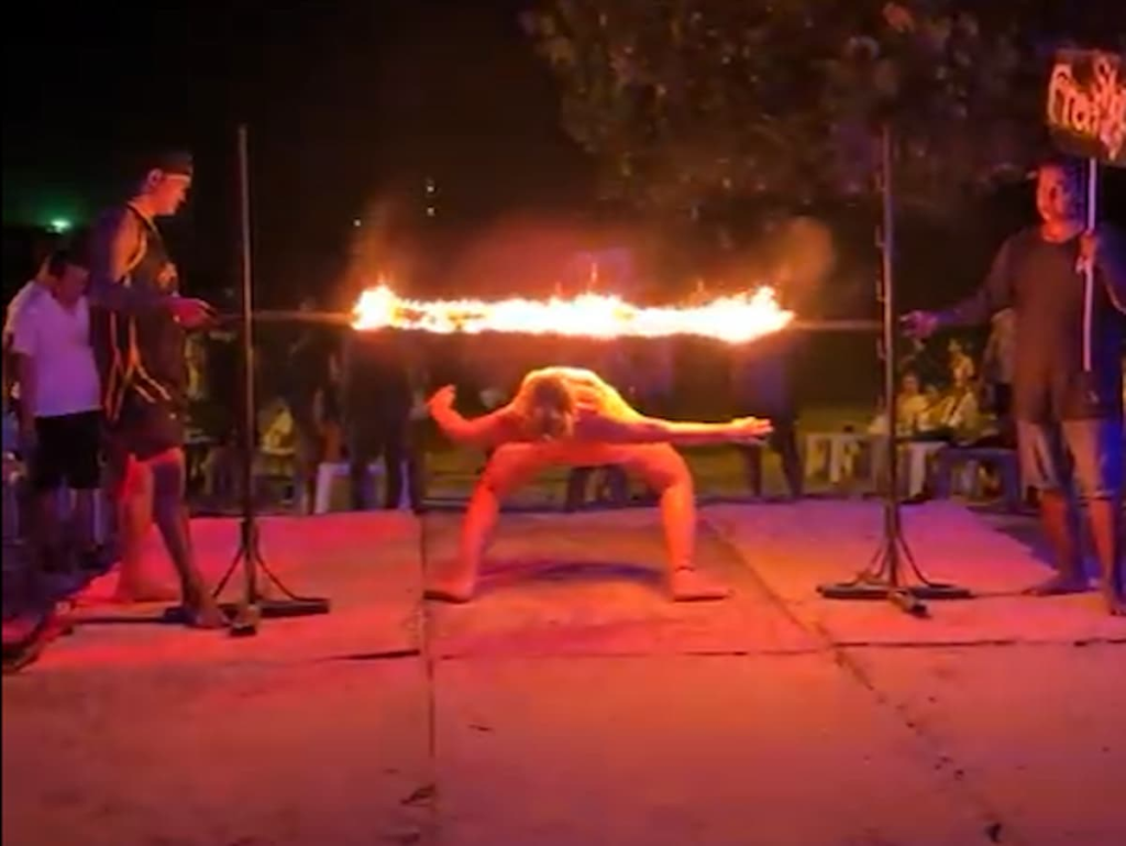 Traveller attempting fire limbo during nightlife in Southern Thailand on Koh Phi Phi.