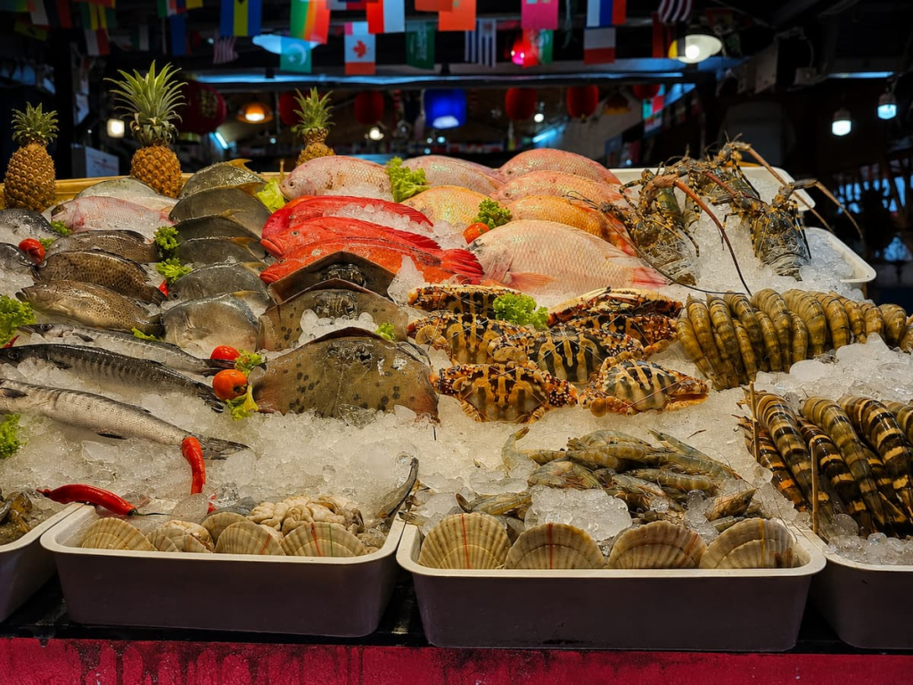 Fresh fish, lobster and shellfish displayed on ice at a seafood restaurant featured in our Karon Travel Guide.