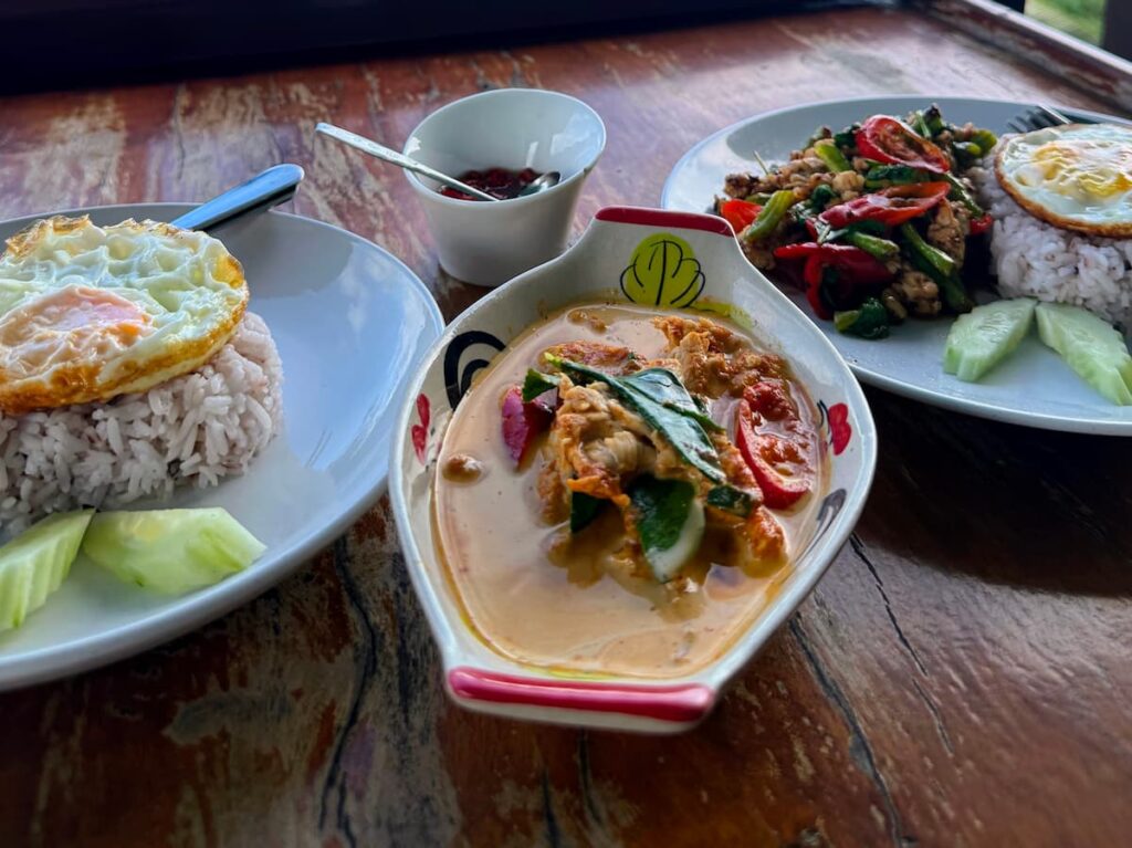 Thai dishes served at Grandma Homemade Thai Food near Patong, including chicken pad kra pao and Phuket-style chicken curry
