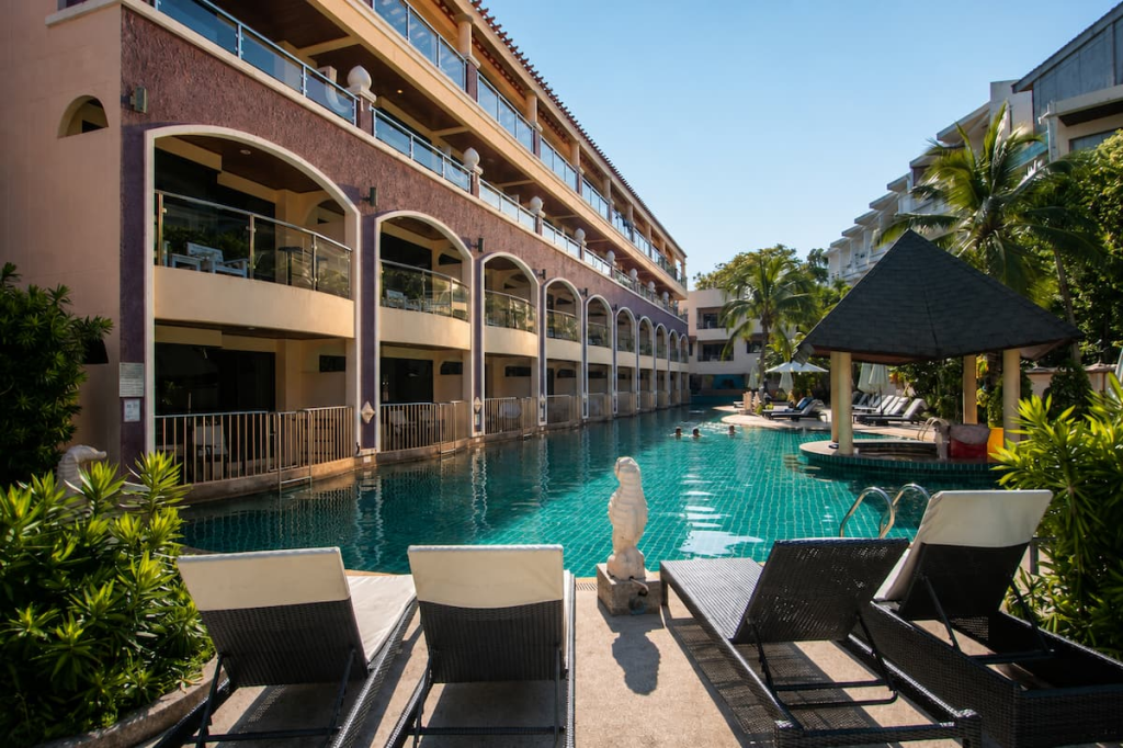 Swimming pool, loungers and private balconies at Karon Sea Sands Resort, featured in our Phuket travel guide.