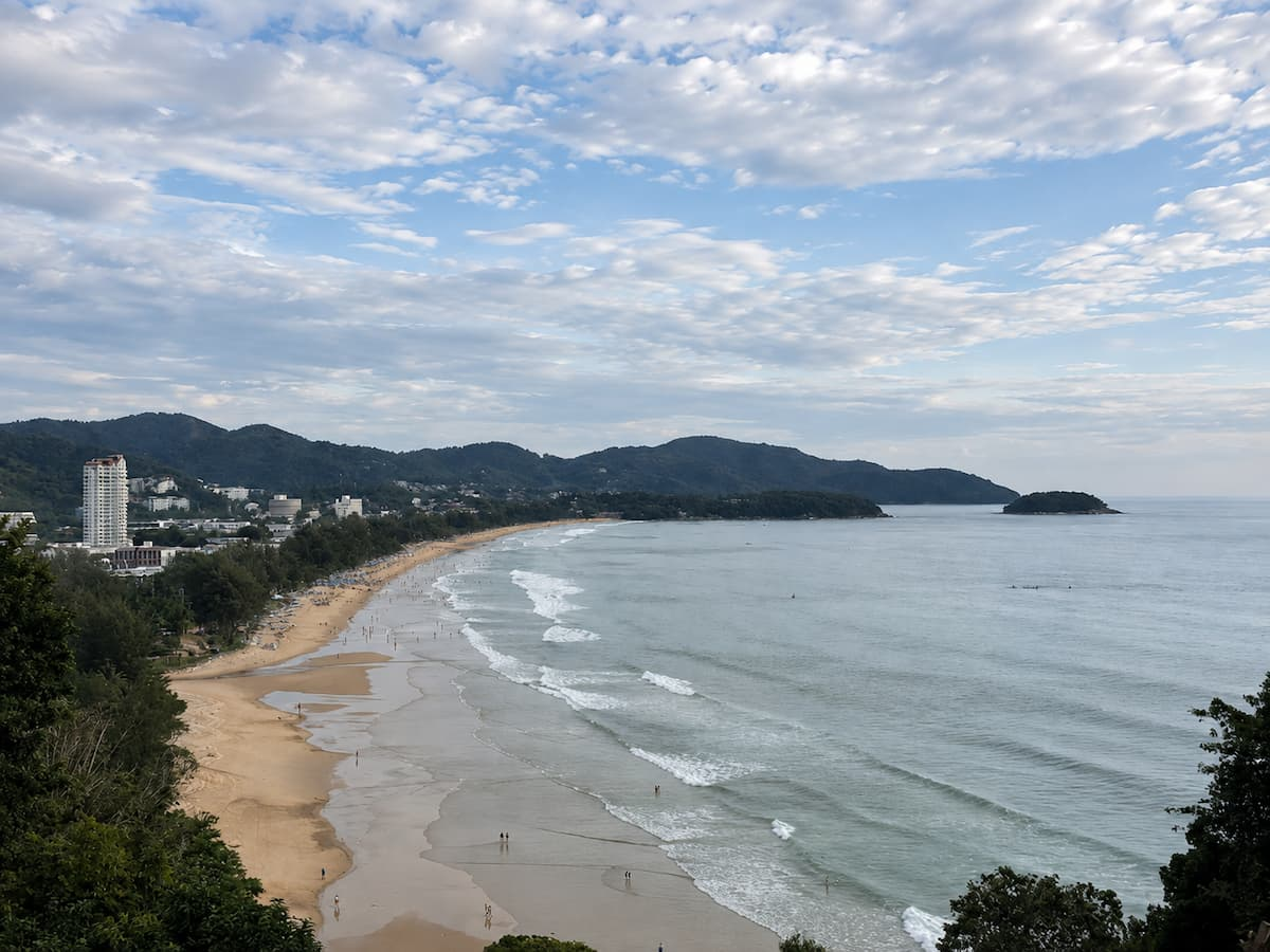 Travel to Phuket with a view over Karon Beach, its long golden-sand coastline and tropical headlands