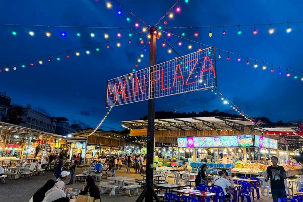Evening atmosphere at Malin Plaza Night Market in Patong with street food stalls, outdoor dining and local shopping.
