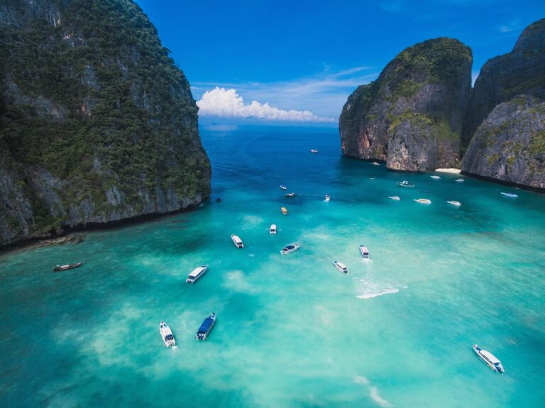 Popular islands in Thailand with limestone cliffs, turquoise Andaman Sea and boats around the Phi Phi Islands