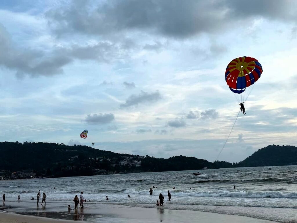 Visitors enjoying parasailing above Patong Beach, Phuket, featured in our Patong Travel Guide.