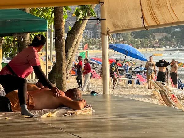 Traditional Thai beach massage beneath the trees at Patong Beach, featured in our Patong Travel Guide as one of the destination's most relaxing wellness experiences.