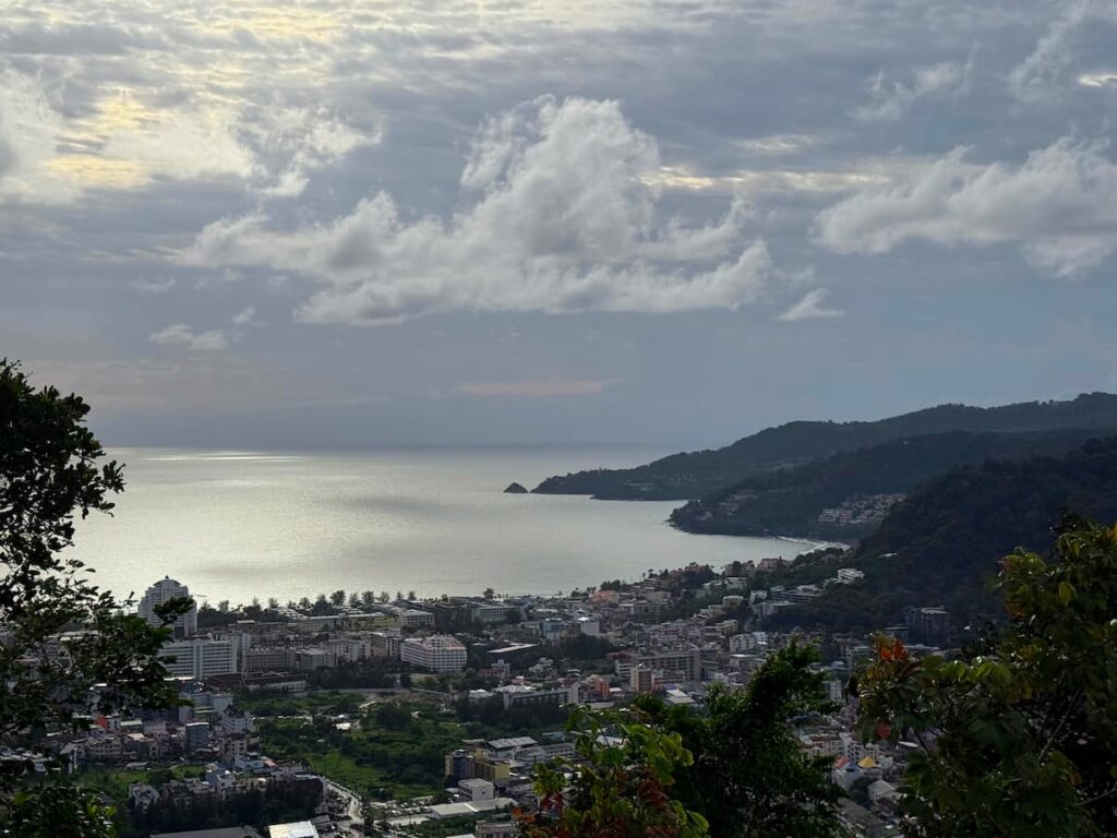 Panoramic view across Patong Bay from Patong Panorama Viewpoint overlooking the coastline and surrounding hills.