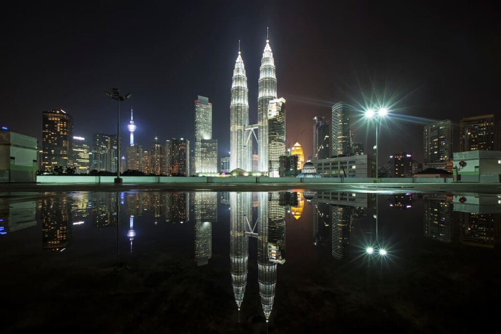Petronas Twin Towers and Kuala Lumpur skyline reflected in water at night for the Malaysia Southeast Asia destination