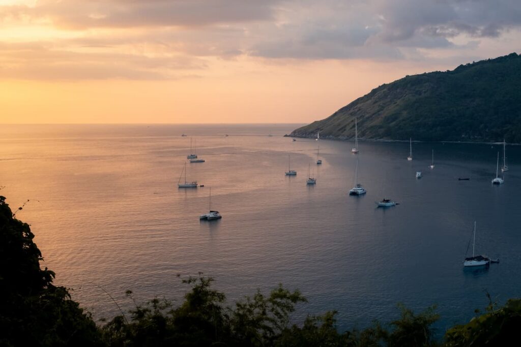 Phuket island in Thailand with yachts anchored in a sheltered bay at sunset. One of the most popular islands in Thailand.