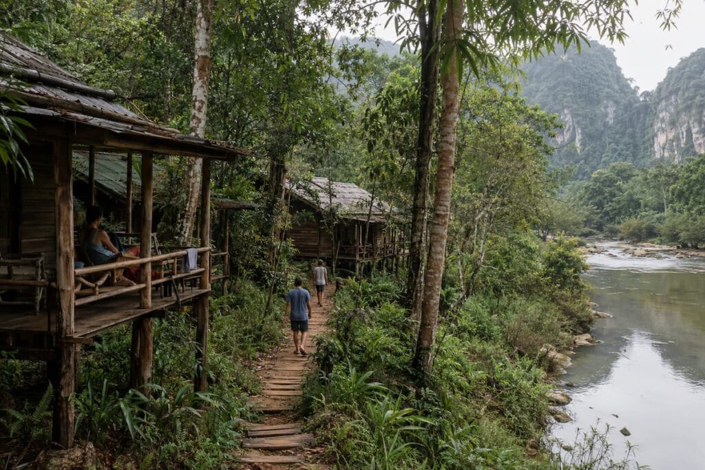 Timber bungalows beside a river and limestone rainforest in Southern Thailand
