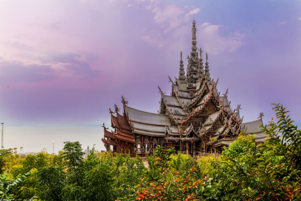 Thailand travel guide view of the intricately carved wooden Sanctuary of Truth surrounded by tropical gardens in Pattaya.