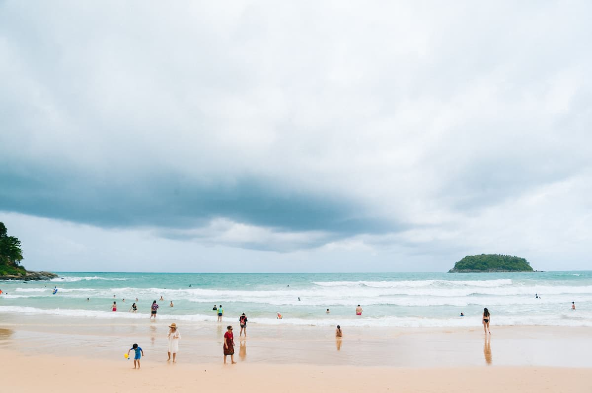 Families enjoying Kata Beach in a practical guide to Southern Thailand with children.