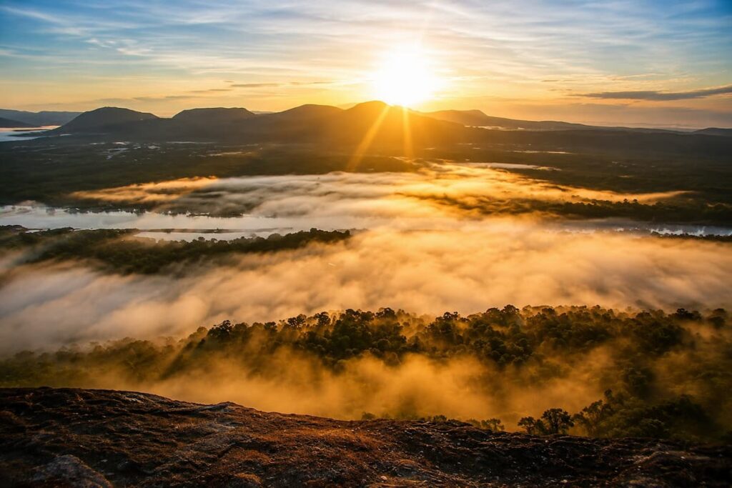 Thailand scenic viewpoints at Pha Chana Dai with sunrise above mist-covered forest and mountains in Ubon Ratchathani